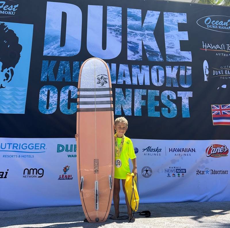 Coral Rajzman, filha do tricampeão mundial Phil Rajzman, participa de campeonato infantil de surfe no Havaí.