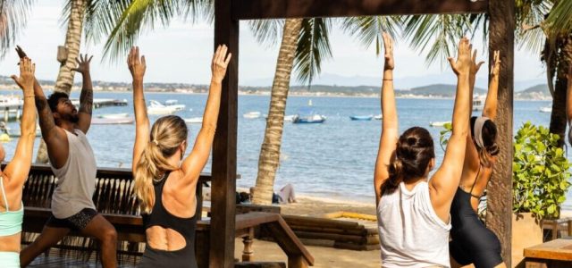 Participantes do evento de bem-estar em Búzios, com atividades de yoga, boxe funcional e imersão no gelo, promovendo saúde e conexão com a natureza.