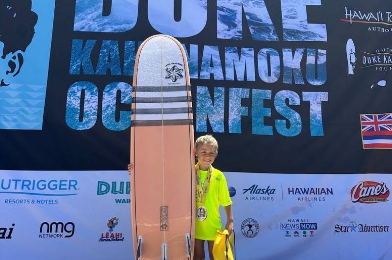 Coral Rajzman, filha do tricampeão mundial Phil Rajzman, participa de campeonato infantil de surfe no Havaí.