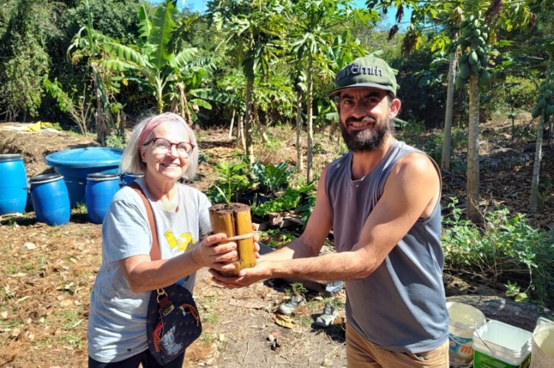 A moradora recebe sua muda das mãos do Daniel - Fotos Prensa de Babel