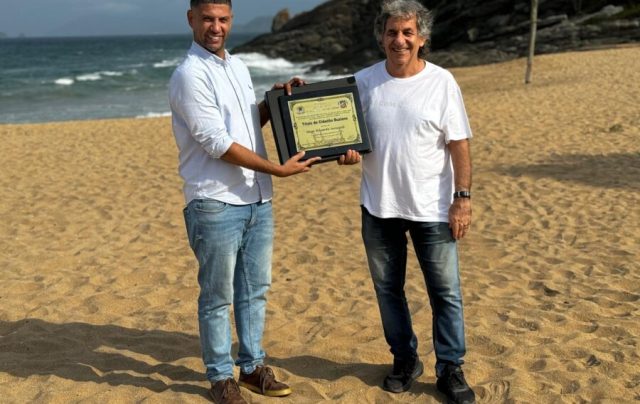 O vereador Gugu de Nair entrega a honraria a Hugo na Praia das Caravelas em Búzios - Foto José Carlos