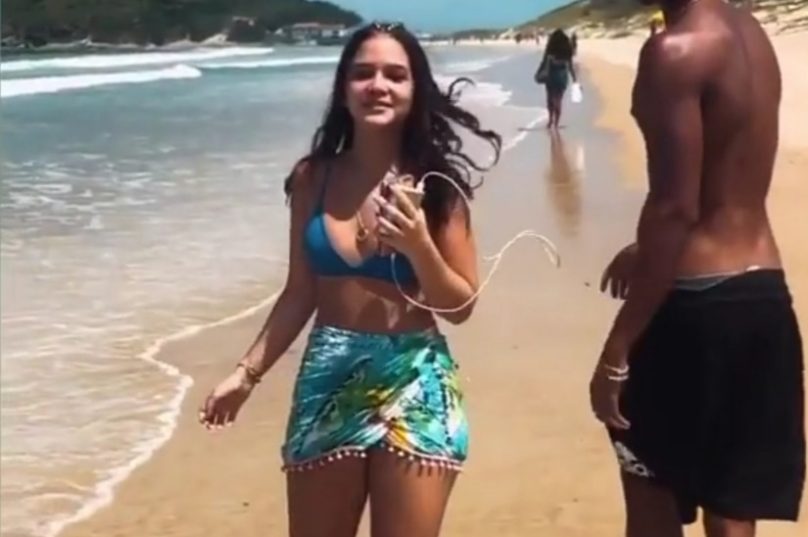 Mel Maia caminhando com João Pedro na Praia do Peró.