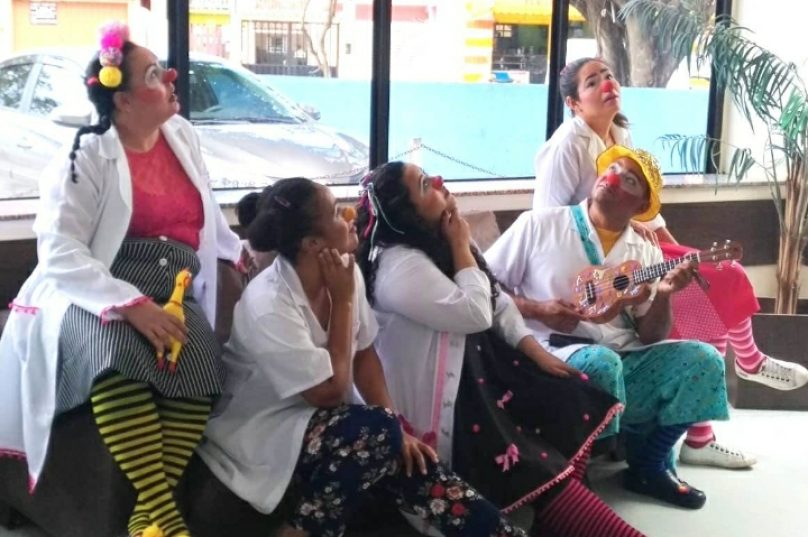 Com jalecos brancos, narizes de palhaço e muita alegria, os voluntários percorrem hospitais pediátricos e centros de atendimentos. Foto: Instituto M25 I Reprodução