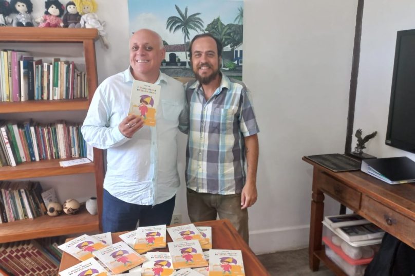 O secretário de Cultura e Patrimônio Histórico de Búzios, Romano Lorenze, recebeu os exemplares de “A Criança Debaixo do Guarda-Chuva” das mãos do autor Victor Viana. Foto: Divulgação
