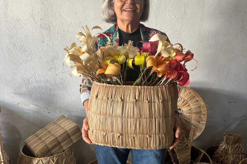 Tia Eva Gomes conduz a oficina “Fibras da Deva” em Búzios, reunindo mulheres para criar escultura coletiva com fibras naturais e celebrar a conexão com a natureza.