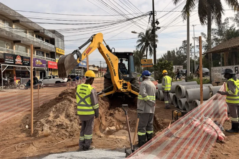 Equipes trabalham em trecho aberto da Avenida Independência durante obras na rede de drenagem em Tamoios.